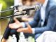 Microphone in focus against blurred people at round table event or business conference.